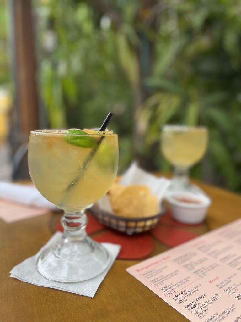 Two large margaritas on a table in the patio